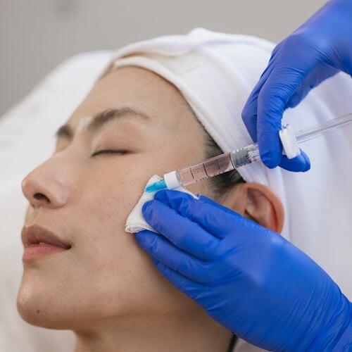 Doctor performing the Korean laser treatment on the patient’s facial skin, targeting pigmentation and uneven skin tone.